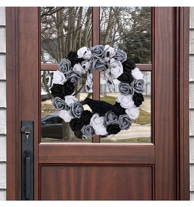 Detail of gothic Halloween wreath featuring black roses and realistic crow model