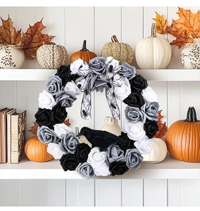 Detail of gothic Halloween wreath with black and white roses, a crow, and spider ribbon