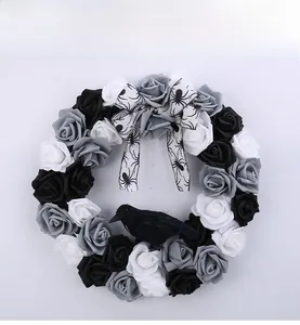 Detail of Halloween wreath featuring black roses, spider bow, and realistic crow decoration