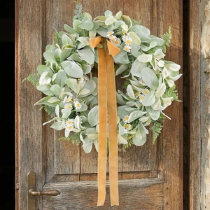 Rustic artificial green leaf wreath with white daisies and orange velvet ribbon on wood door