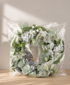 Eucalyptus wreath packaged in clear bag with striped bow and small blue flowers