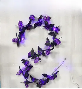 Detail of purple artificial rose vine with LED lights and black leaves for Halloween decoration