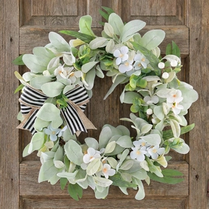 Künstlicher Eukalyptus-Frühlingskranz mit weißen Blumen und Schleife an der Holztür