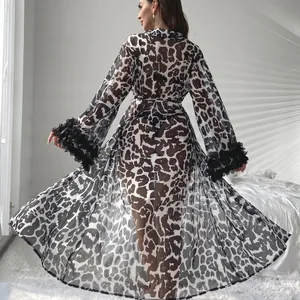 Long leopard print sheer nightgown with black ruffled cuffs in a minimalist bedroom setting