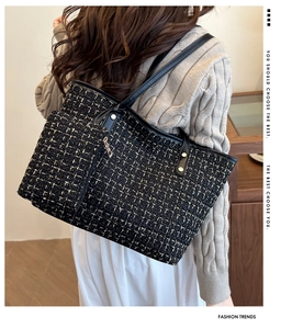 Vue latérale du sac cabas en tweed noir avec fils dorés sur un pull beige doux