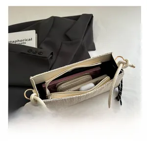 Top view of woven beige envelope bag showing interior capacity with phone and wallet