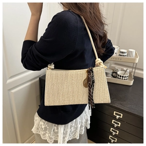 Detail of handwoven shoulder bag with retro golden tennis racket charm and silk scarf