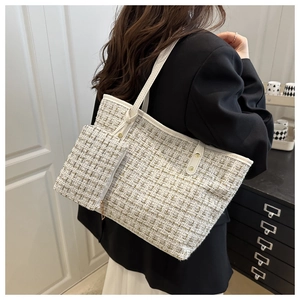 Détail du sac cabas en tweed montrant le tissu texturé et une mini pochette latérale