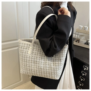 Détail du sac cabas en tweed avec bandoulières en cuir beige et rivets dorés élégants
