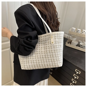 Détail du sac cabas en tweed blanc cassé avec rivets dorés et bandoulière en cuir