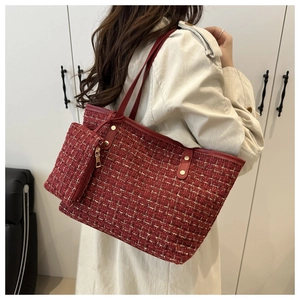 Détail du sac cabas en tweed rouge avec poignées en cuir sur un mannequin en manteau
