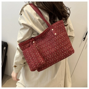 Détails de la texture tissée en tweed rouge et clous dorés sur ce sac cabas élégant