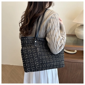 Détail du sac cabas en tweed avec fil doré et fines lanières en cuir sur un modèle