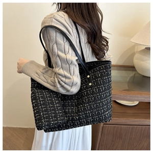Détail du cabas en tweed avec texture tissée noir et or et bandoulière en cuir