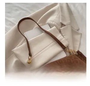 Détail du sac à main léopard avec bandoulière en cuir marron et chaîne dorée