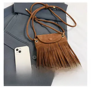 Brown fringe bucket bag size comparison with a smartphone on a grey blazer
