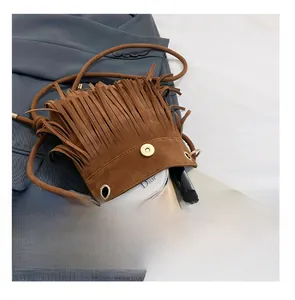 Detail presentation showing the spacious interior capacity of a brown suede tassel bucket bag
