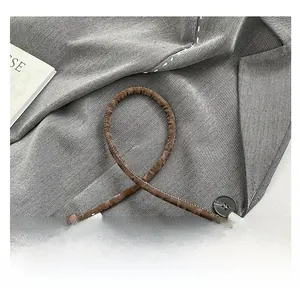 Détail du sac à main marron foncé avec poignée nouée et texture effet écorce