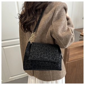 Détail du sac cabas en daim noir avec chaîne dorée et large bandoulière noire