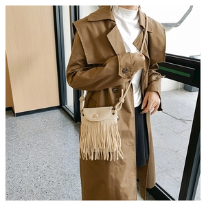 Detail of bohemian cream fringe crossbody bag with long tassels and stylish knot strap
