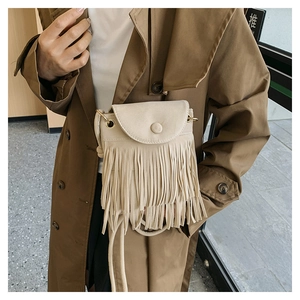 Detail of cream tassel shoulder bag featuring soft matte texture and long fringe accents