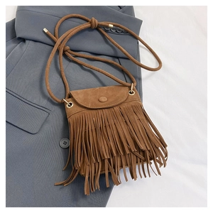 Detailed view of brown fringe bucket bag with soft suede texture and gold metal rings