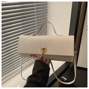 Detail of off-white woven shoulder bag featuring a gold twist lock and fine grain texture