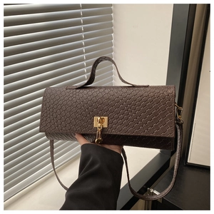 Close-up of dark brown woven shoulder bag with golden lock clasp and leather strap