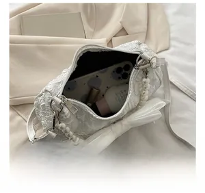 Interior view showing capacity for smartphone and makeup in a white bow pearl handbag