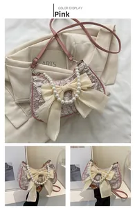 Detailed close-up of pink ruched cloud bag featuring cream bow and pearl chain handle