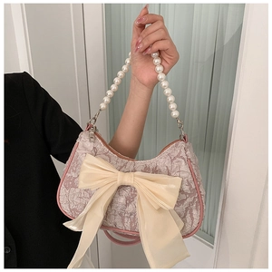 Detail of lavender pleated fabric bag with large chiffon bow and pearl handle