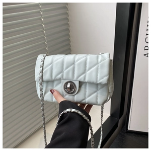 Détail d'un sac bandoulière matelassé bleu menthe avec fermoir rotatif argenté