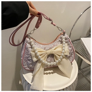 Detail of pink jacquard bag with large organza bow and pearl bead handle decoration