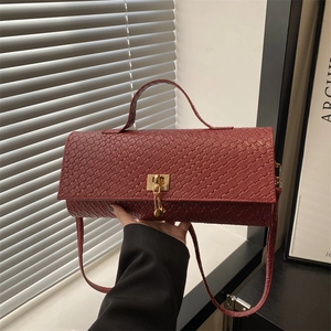 Red-brown woven texture baguette bag with golden buckle and crossbody strap for women
