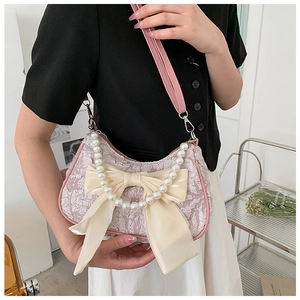 Detailed shot of pink floral handbag with large silk bow and decorative pearl handle