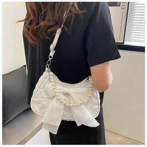 Detail of white jacquard bag with large chiffon bow and luxury pearl handle chain