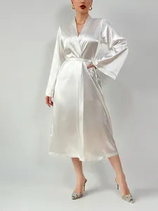 Detail of white satin long robe showing the silky texture and elegant belted waist design