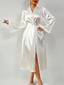 Detail of elegant white satin long-sleeve robe featuring a smooth silky texture and waist tie