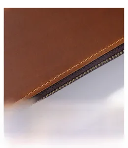 Macro detail of high-quality brown leather texture with precise yellow stitching and zipper