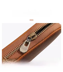 Detail view of the vintage brass zipper on the brown crazy horse leather pen case