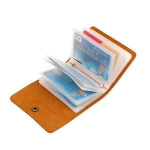 Detail of brown pebbled leather card holder showing multiple PVC card slots and metal snap