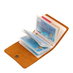 Close-up of brown leather card holder with multiple transparent PVC slots and snap button