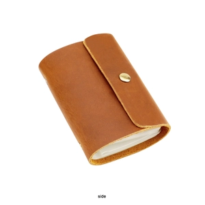 Side view of brown leather credit card holder with gold button and multiple slots