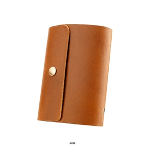 Side view of brown leather card wallet with metal snap button and vintage texture