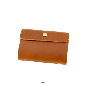 Side view of a vintage brown genuine leather card holder with a metal snap closure
