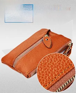 Detailed close-up of orange cowhide leather wallet showing lychee grain and fine stitching