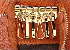 Detail of six gold metal key hooks inside a brown lychee pattern leather wallet