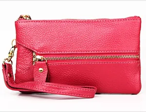 Detail of rose red pebble leather coin purse with golden zipper and wrist strap