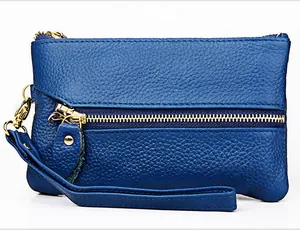 Detail of blue lychee grain leather wallet with gold zipper and wrist strap
