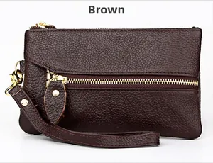 Detailed macro view of dark brown pebbled leather texture and golden zippers on the wallet